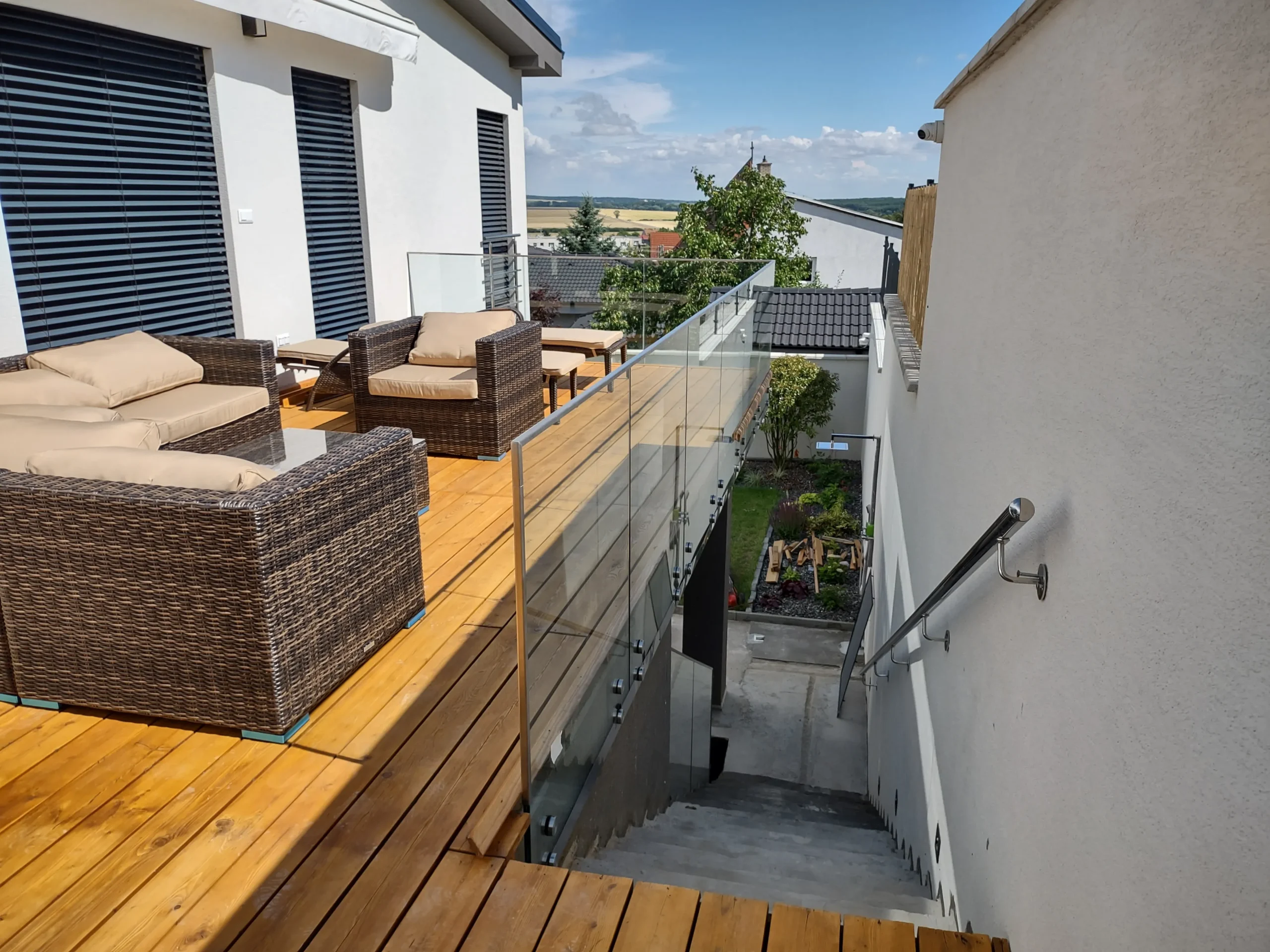 Samonosné sklenené zábradlie na terase rodinného domu s bodovým uchytením o betónový veniec.