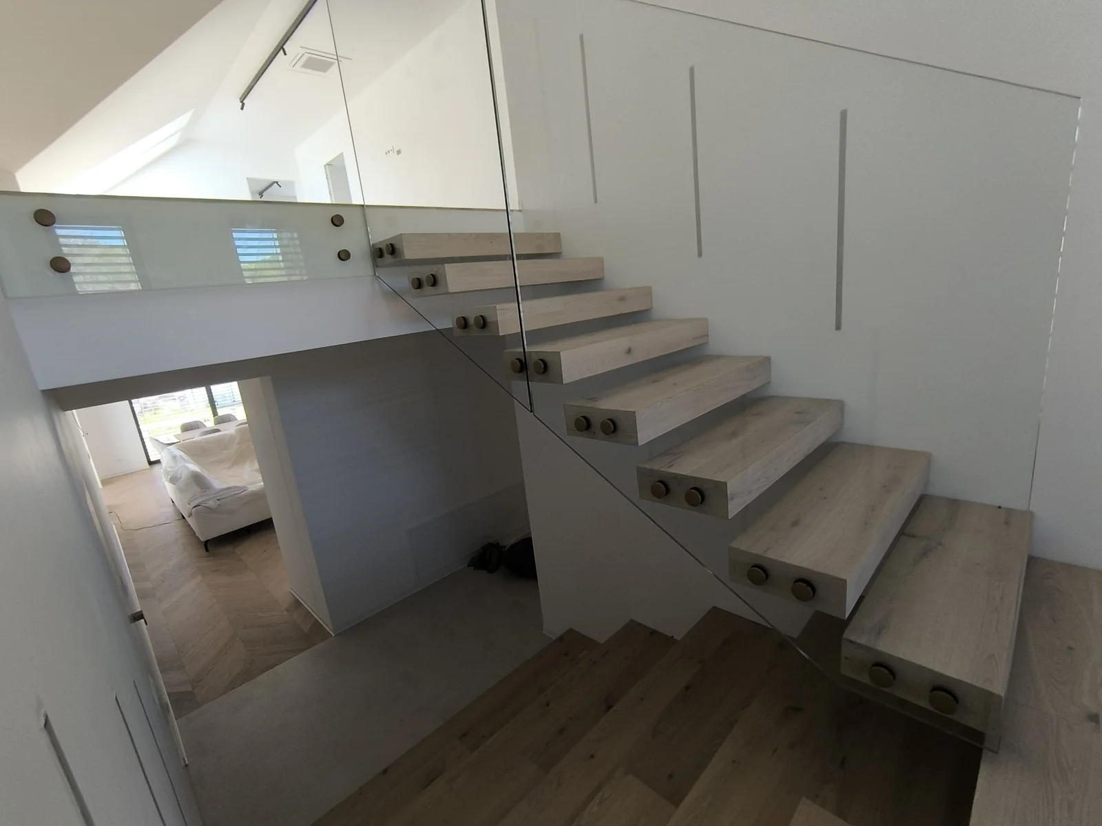 sklenené zábradlie na drevené schodisko s presklenou stenou a otvoreným priestorom