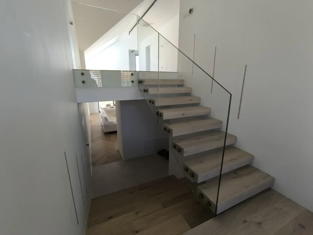 sklenené zábradlie na drevené schodisko v modernom interiéri s presvetlením