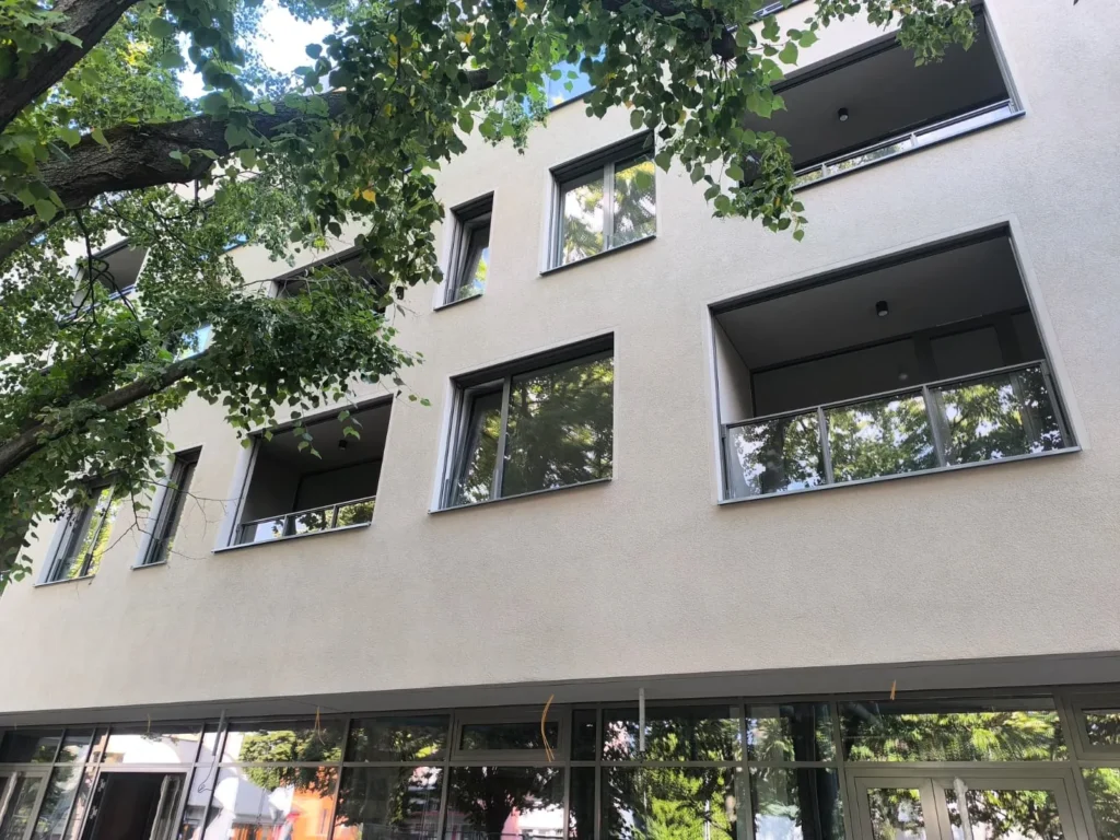 Sklenené rámové zábradlie na lodžiu na fasáde moderného bytového domu.